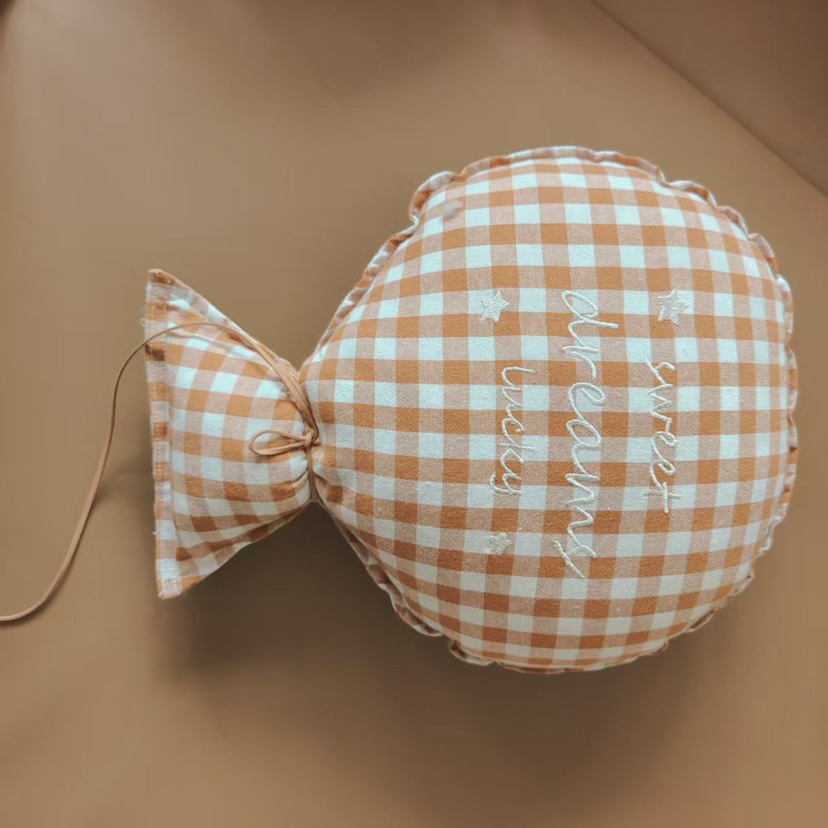 Balloon-shaped nursery cushion with an embroidered message on a nursery shelf – Brown Gingham, Sweet Dreams Lucky