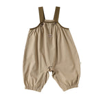 Light Khaki cotton baby dungarees with adjustable straps, flat lay