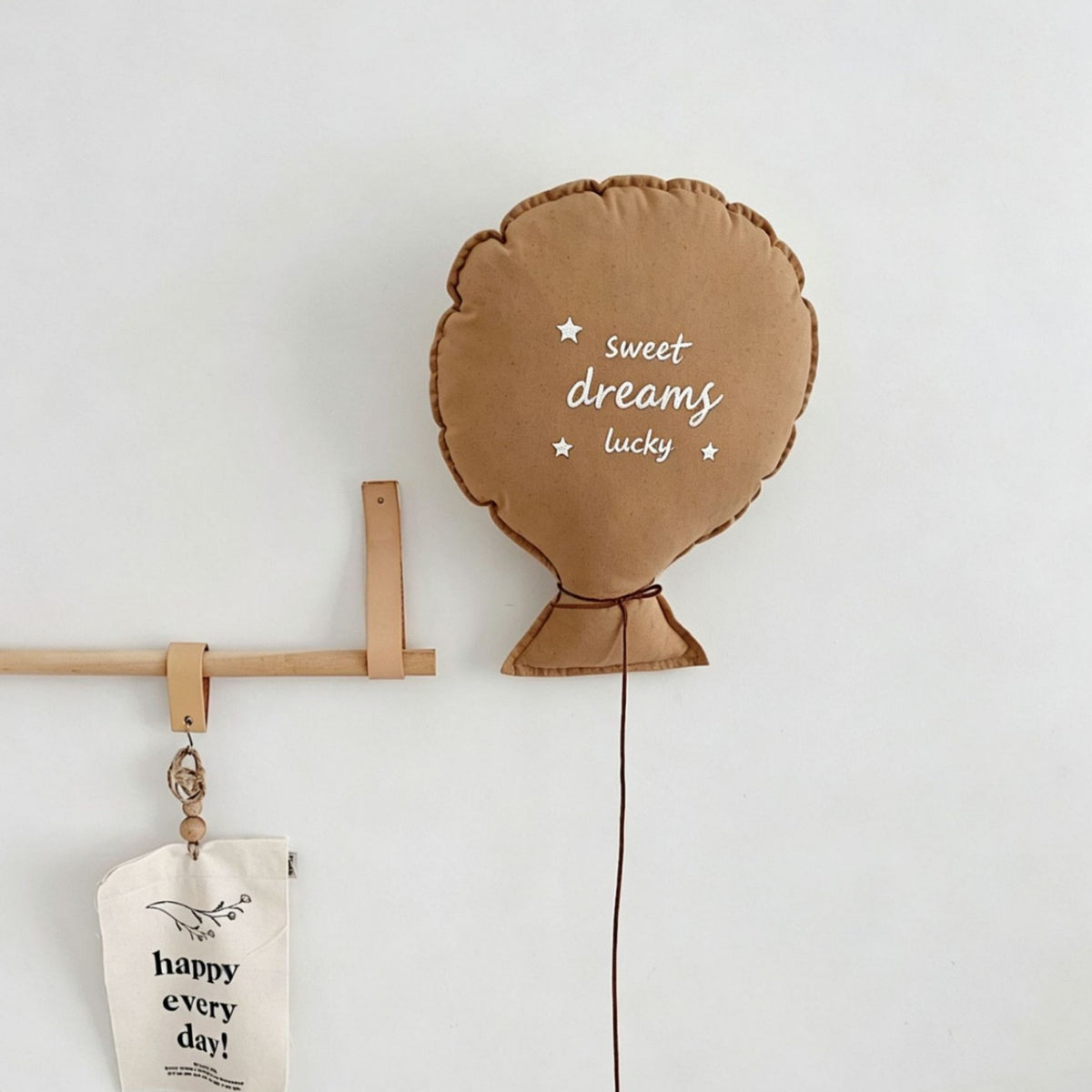 Balloon-shaped nursery cushion with an embroidered message on a nursery shelf – view 2 of 11