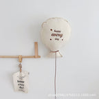 Balloon-shaped nursery cushion with an embroidered message on a nursery shelf – view 3 of 11
