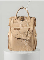 Changing bag backpack with round magnetic buckle, top handles and side pockets – view 10 of 13