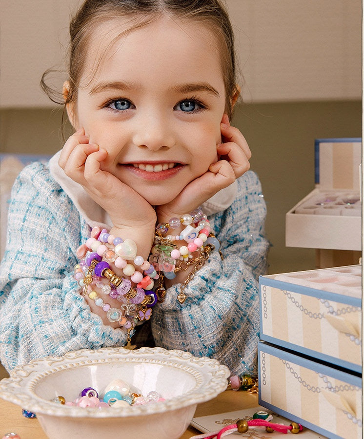 Smiling girl wearing beaded charm bracelets she made with the kit