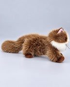 Realistic brown and white Ragdoll-style cat plush toy, lying down, side view