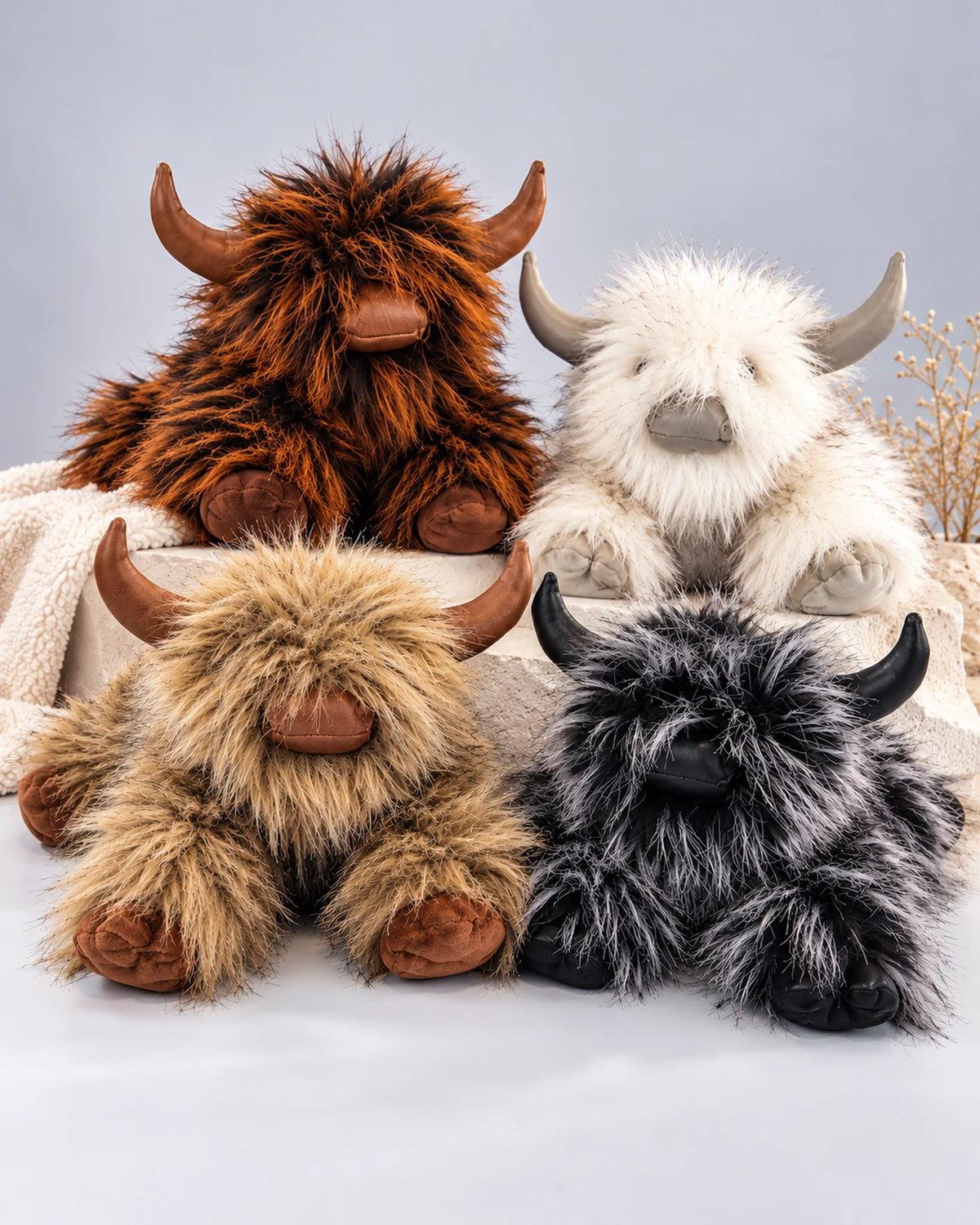 Four Highland cow plush toys in Rustic Brown, Golden Tan, Smoky Black and Frost White
