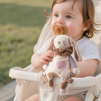 Cream plush bunny hand puppet comforter with ruffled collar and flower teether