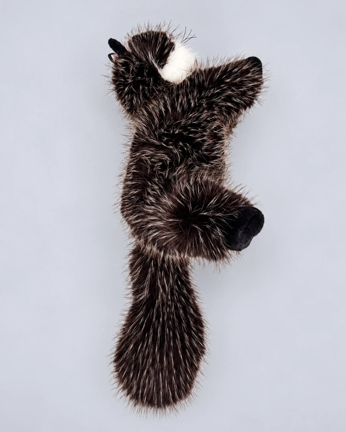 Realistic black cat plush toy, lying down, back view
