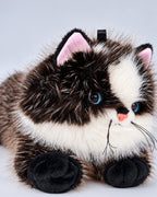 Realistic black cat plush toy, lying down, close-up