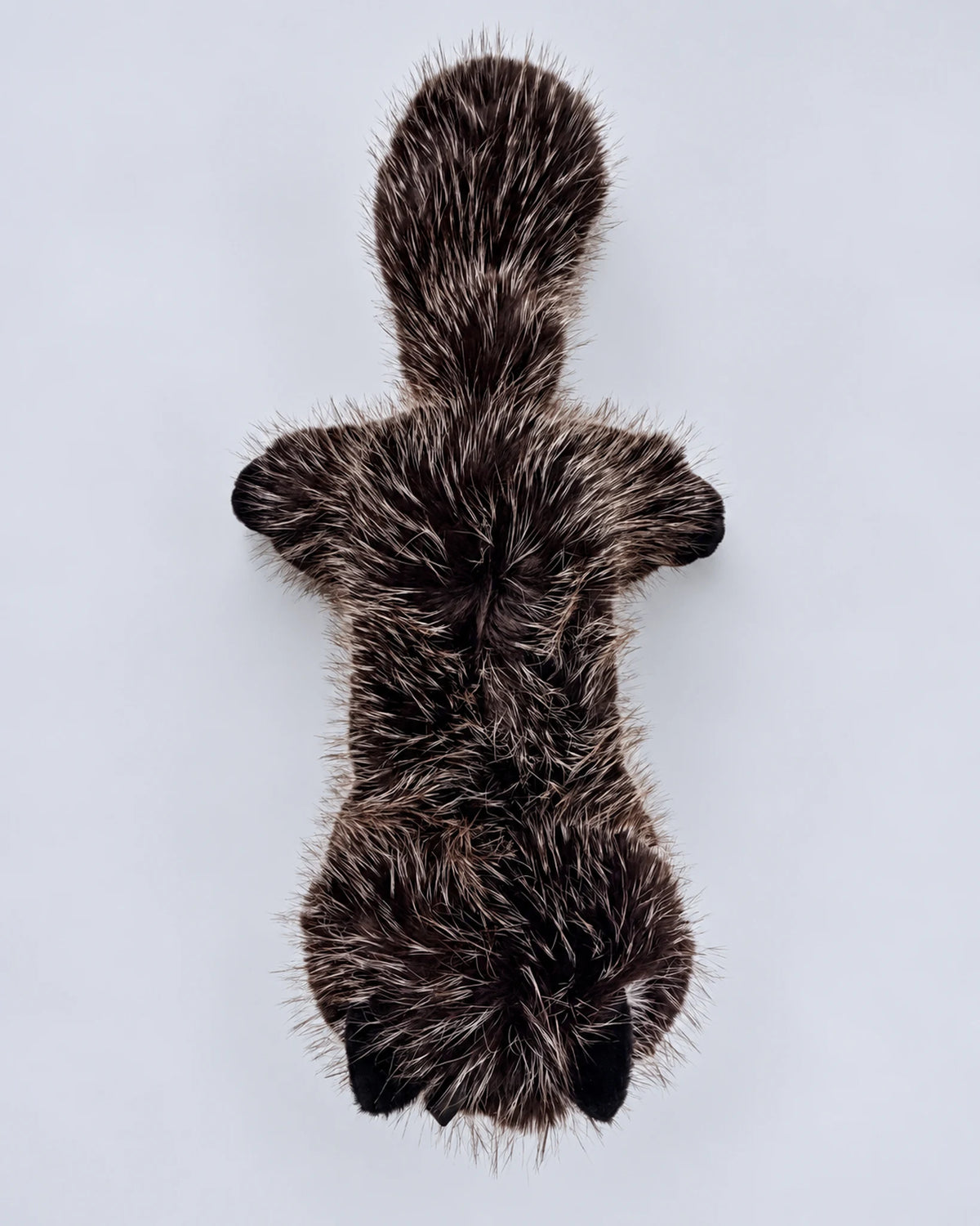 Realistic black cat plush toy, lying down, top view