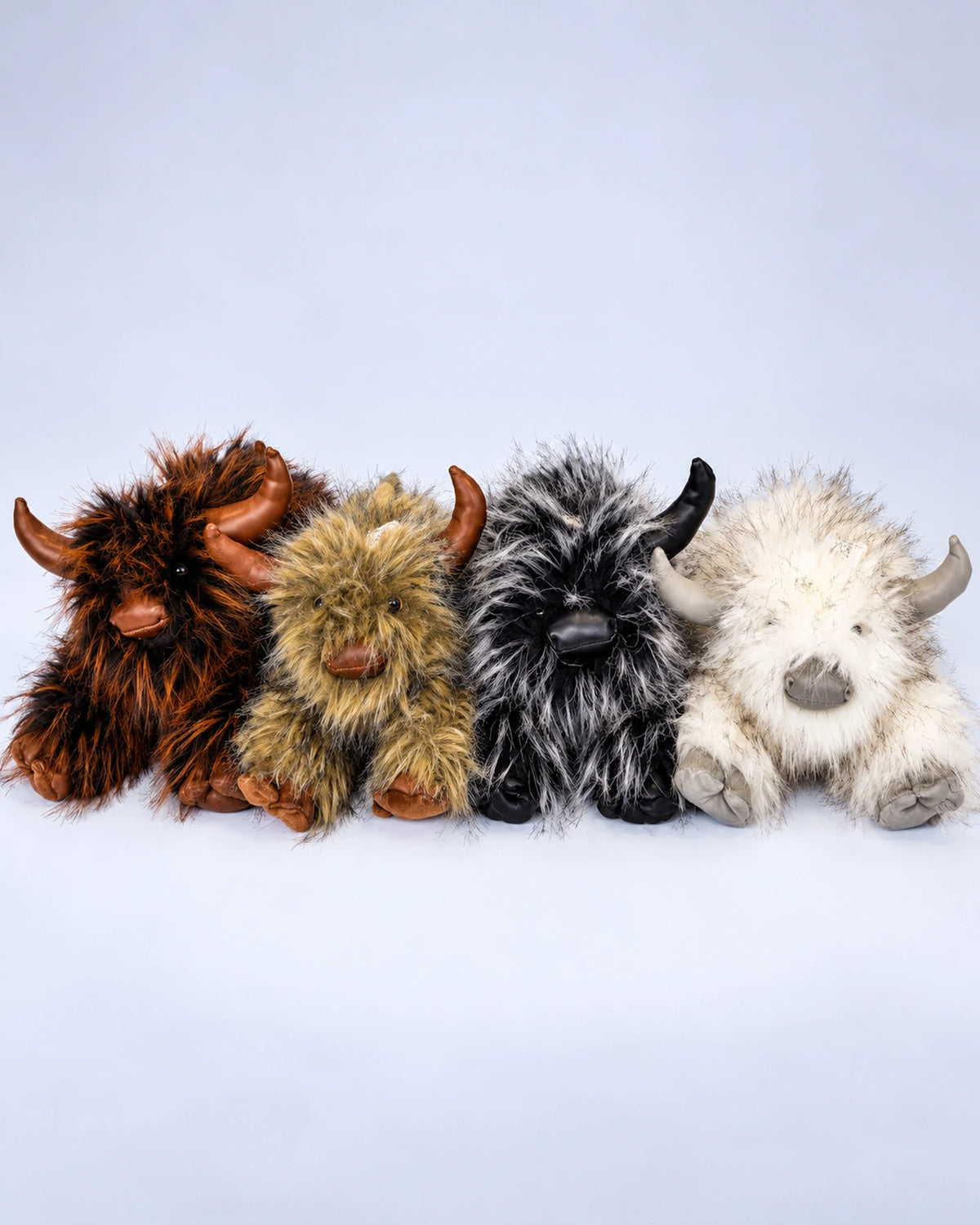Four Highland cow plush toys in Rustic Brown, Golden Tan, Smoky Black and Frost White