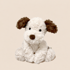 Soft plush puppy soft toy, 35 cm long, lying on a bed